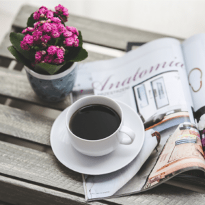 cup of coffee with magazine and fresh flowers