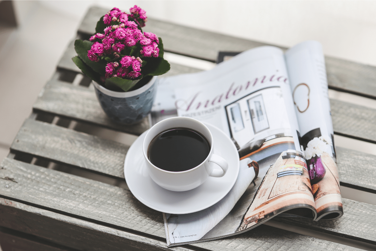 cup of coffee with magazine and fresh flowers