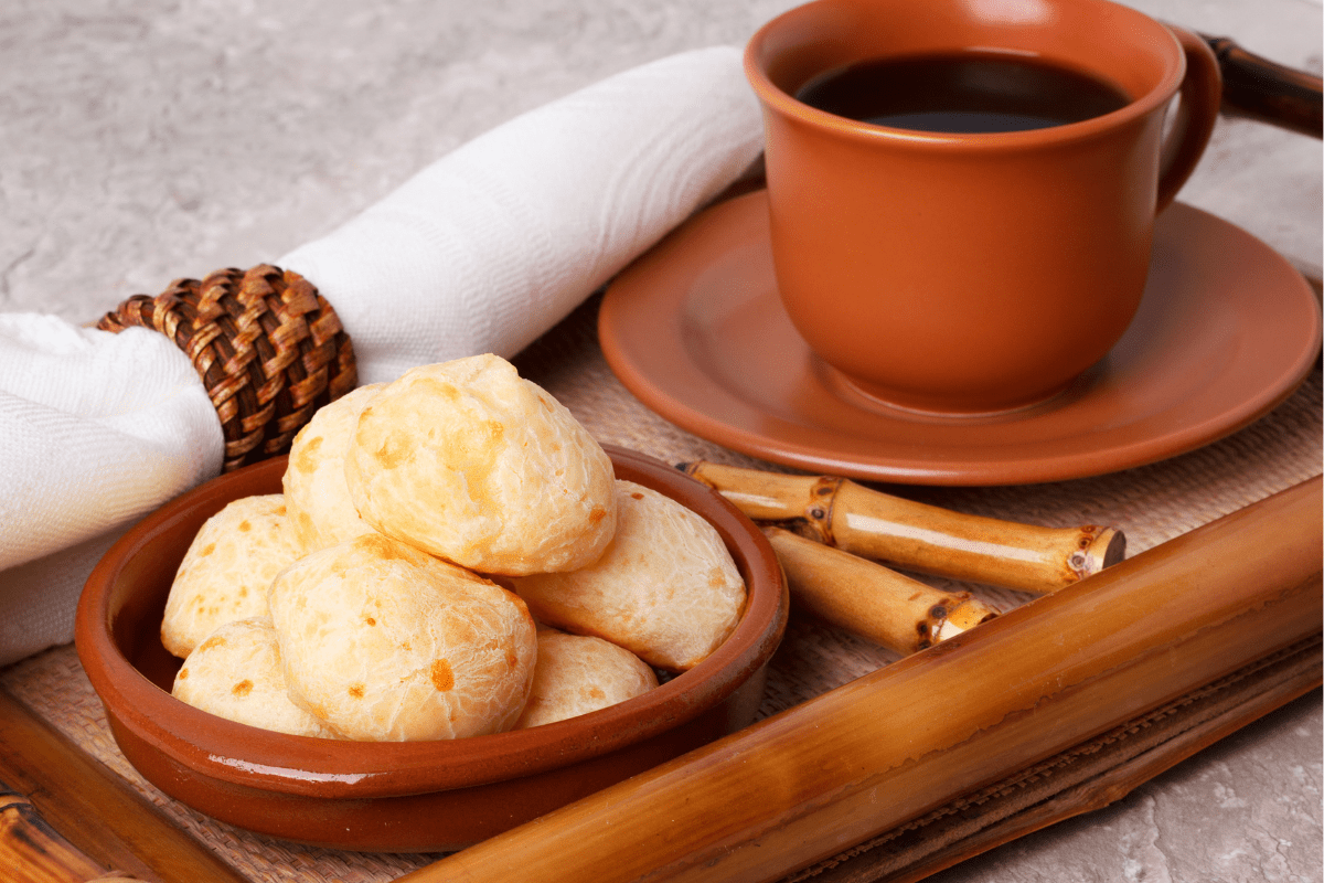 Brazilian cheese bread on tray with coffee