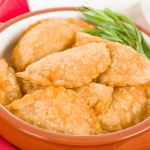 pastel de queijo on a serving platter with dipping sauce