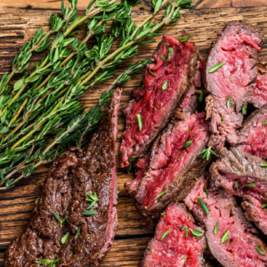 medium rare churrasco steak sliced thin and garnished with rosemary