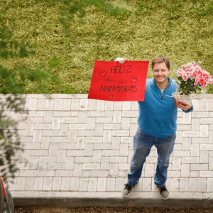 man with sign that says "happy valentine's day" in Portuguese